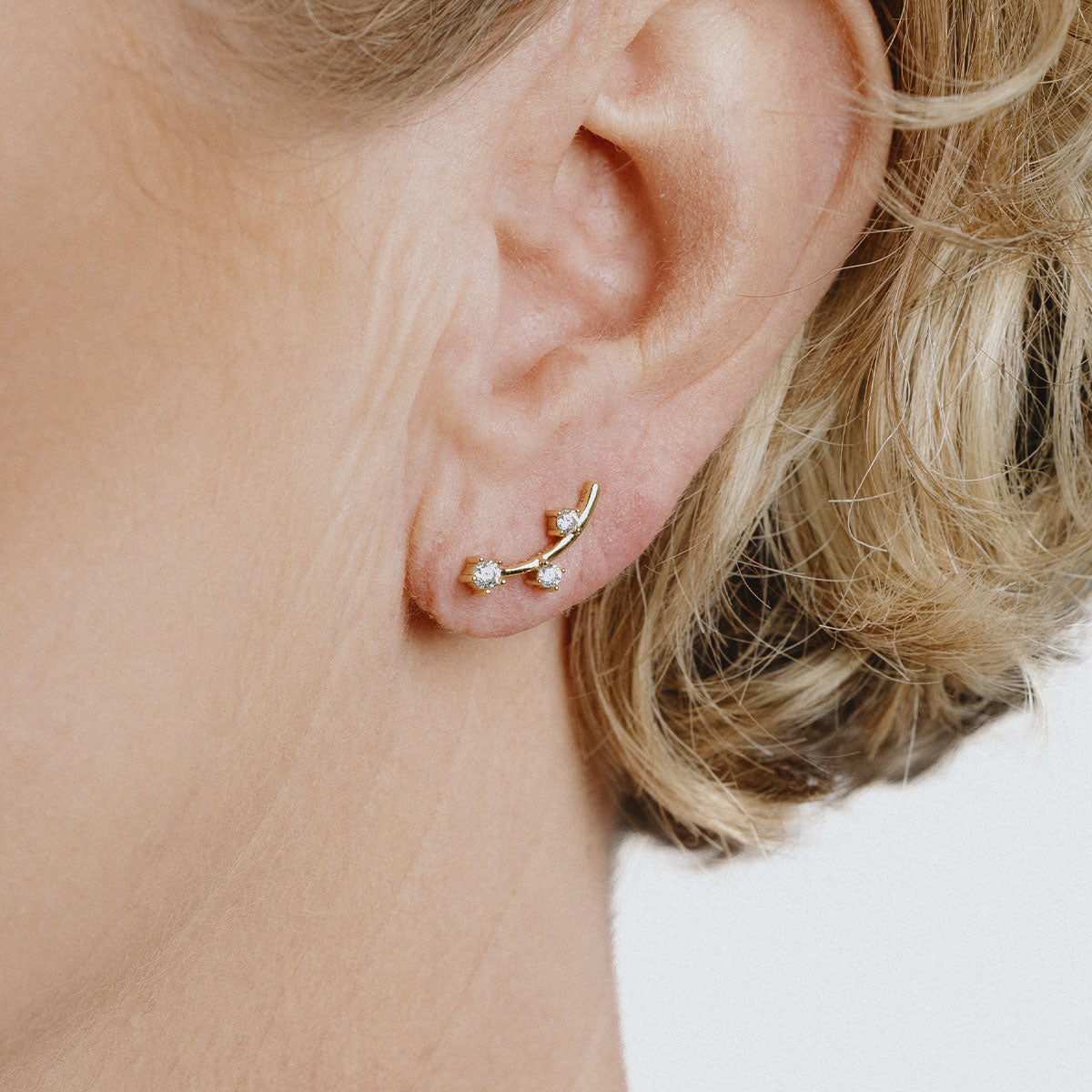 Golden earrings in vertical line with 3 stones